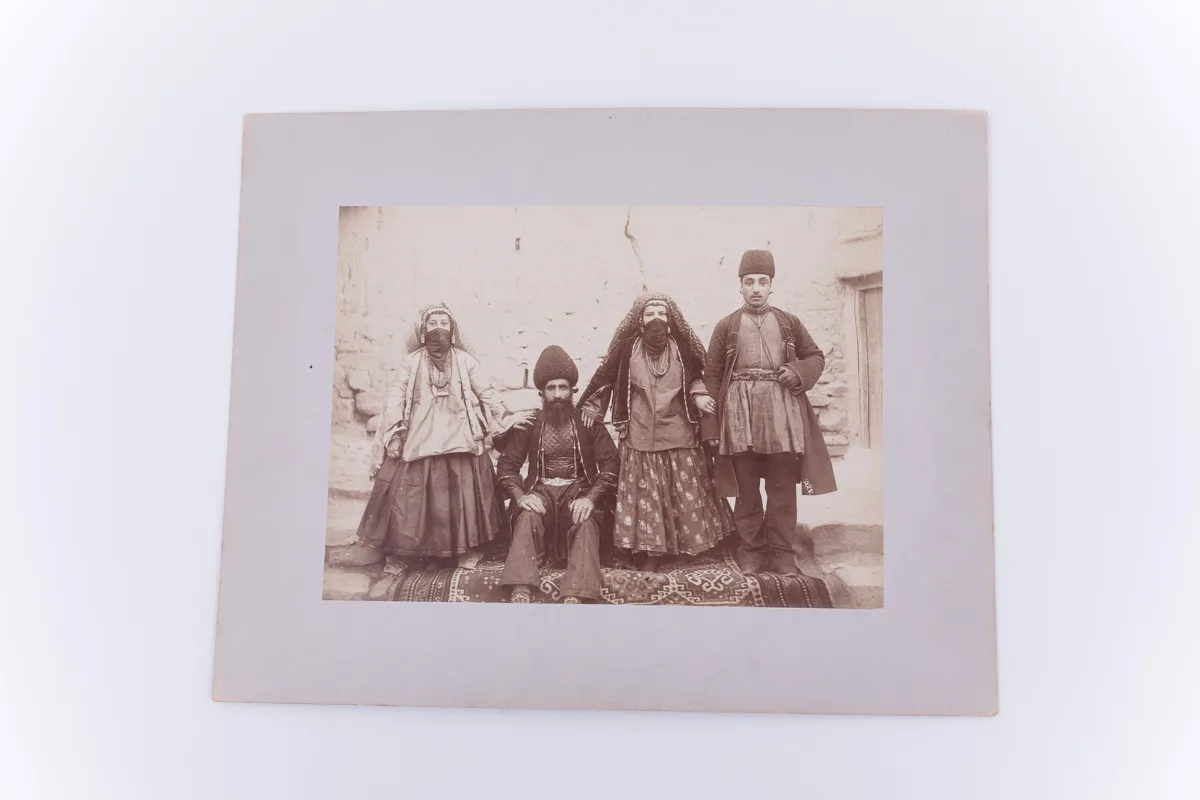 Fotografie de exterior ce prezintă o familie de evrei (?) din Teheran, Iran. Imaginea este realizată pe hârtie albuminată, după un clișeu pe sticlă și este lipită pe un carton gros, de culoare gri. Ac — تصویر رکورد یوروپیانا