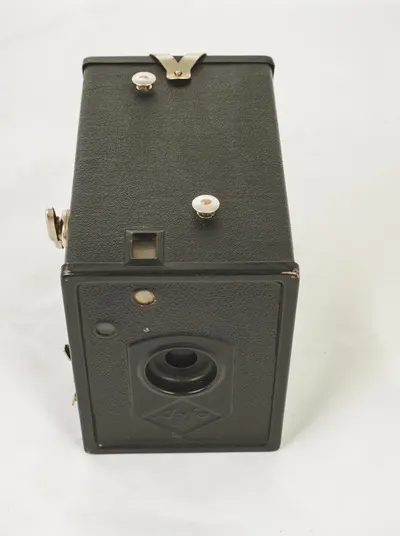 Aparat fotografic tip Box Camera, marca "Agfa Preisbox'' sau Agfa Box 44, produs de firma germana Agfa între anii 1932-1936. Este compus dintr-o carcasă paralelipipedică metalică, opacă, vopsită în ne — تصویر رکورد یوروپیانا