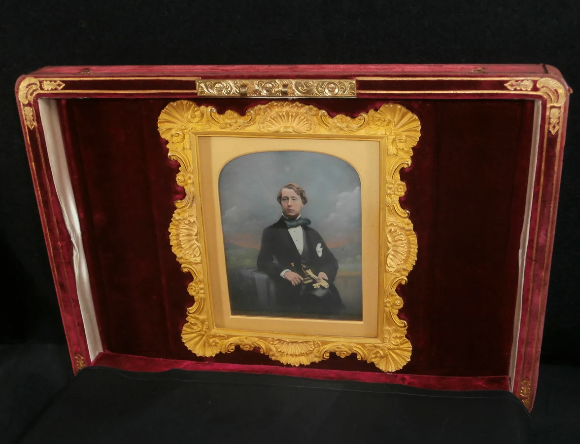 A red velvet covered toiletry box with decorative gold tooling and grooves with an engraved silver gilt plaque inset into the top. Hidden inside the box lid behind a white padded velvet cover and set  — تصویر رکورد یوروپیانا