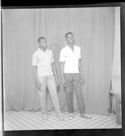 Two young men each wearing a white shirt and a wrist watch standing in profile in the studio. — تصویر رکورد یوروپیانا
