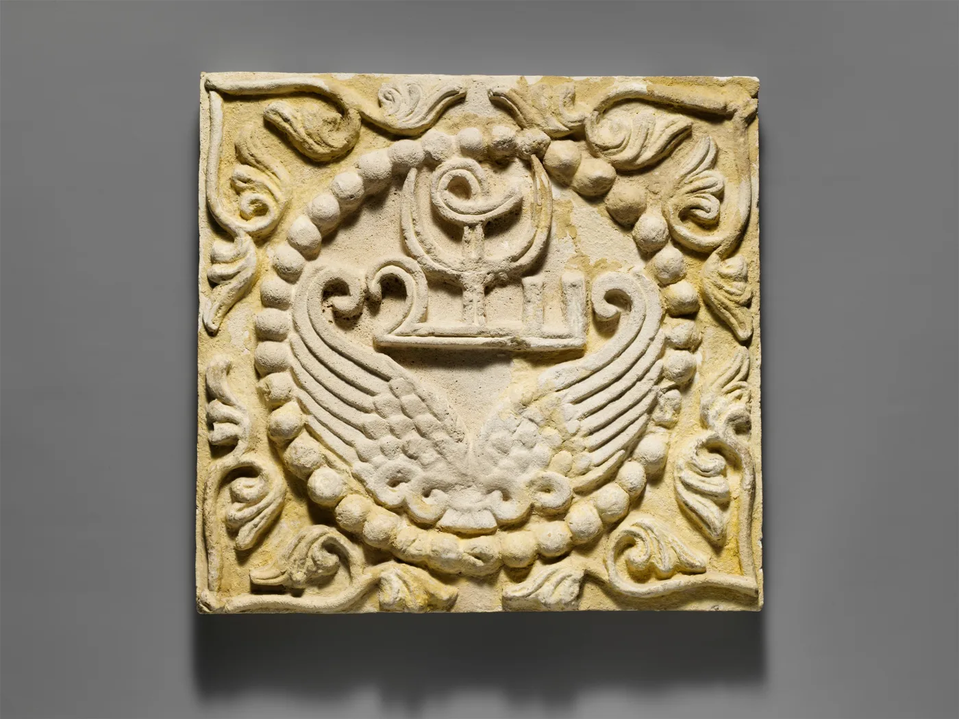 Wall panel with wings and a Pahlavi device encircled by pearls — تصویر رکورد موزهٔ متروپولیتن (دسترسی آزاد)