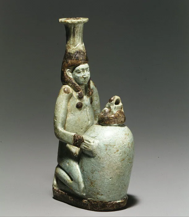 Faience double-spouted vessel in the form of a kneeling woman holding a jar — تصویر رکورد ویکیداده