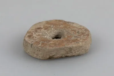Jeton în curs de prelucrare; dintr-un fragment ceramic – șlefuit pentru rotunjire, fără a fi perfect rotundă; perforație din ambele sensuri. — تصویر رکورد یوروپیانا