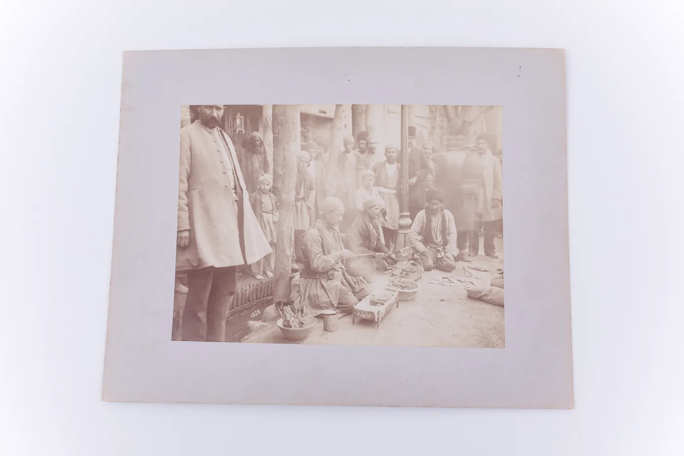Fotografie de exterior ce prezintă un grup de bărbați și copii pe o stradă din Iran. În centrul imaginii se află doi tineri care pregătesc Jigaraki (specialitate iraniană din ficat de oaie). Imaginea  — تصویر رکورد یوروپیانا