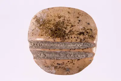 Jeton de formă discoidală, realizat prin tăiere dintr-un fragment ceramic. Pe una din fețe se pot observa două linii paralele, incizate. — تصویر رکورد یوروپیانا