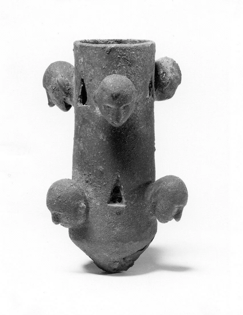 Tubular object with projecting human heads and triangular cut-outs — تصویر رکورد موزهٔ متروپولیتن (دسترسی آزاد)