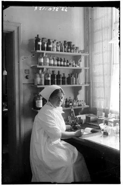 Hålahult sanatorium, interiör, kvinna vid mikroskop, laboratoriemiljö? — تصویر رکورد یوروپیانا