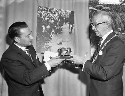 Uitreiking prijzen World Press Photo door burgemeester Kolfschoten in het Gemeentelijk Museum te Den Haag. Burgemeester Kolschoten (r) reikt de Zilveren Camera uit aan fotograaf Ben van Meerendonk — تصویر رکورد یوروپیانا