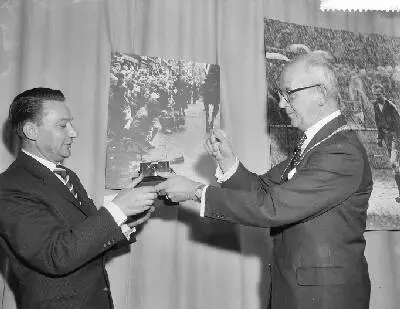 Uitreiking prijzen World Press Photo door burgemeester Kolfschoten in het Gemeentelijk Museum te Den Haag, links de Nederlandse fotograaf Ben van Meerendonk, winnaar van de Zilveren Camera, hem overha — تصویر رکورد یوروپیانا