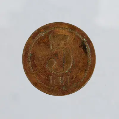 Tehnica: batere; Muchia: netedă; Aversul: Monograma JP cu litere stilizate suprapuse, semnătura JPetcu, cu litere cursive în partea inferioară. Cerc perlat exterior.; Reversul: Valoarea piesei - 5 / L — تصویر رکورد یوروپیانا