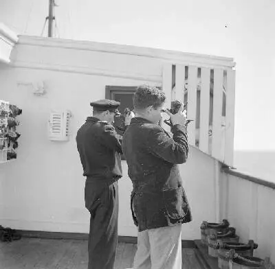 Twee mannen aan boord van een schip kijkend door een sextant — تصویر رکورد یوروپیانا