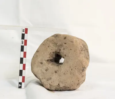 Greutate de pescuit, realizată dintr-un fragment ceramic, cel mai probabil o cărămidă. Pasta este de culoare roșcat-deschis, de consistență rugoasă, cu intruziuni de nisip și pietriș. Forma piesei est — تصویر رکورد یوروپیانا