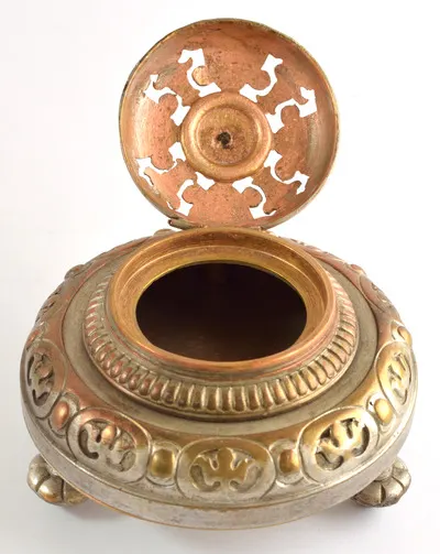 Călimară de birou, din bronz, formă rotundă, cu capac bombat și buton, 3 picioare sub formă de butoni. Recipientul este bogat ornamentat, baza gâtului este decorată cu o bandă de linii paralele. Capac — تصویر رکورد یوروپیانا
